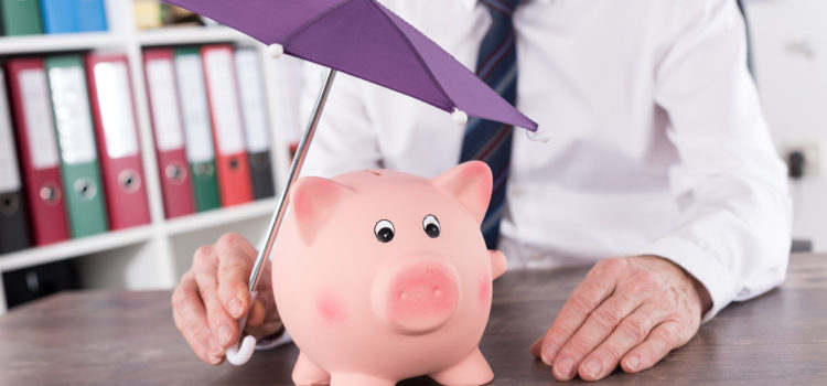 a man holding an umbrella over a piggy bank representing money protection