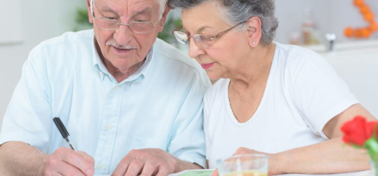 Elderly couple looking at a mortgage and taking notes