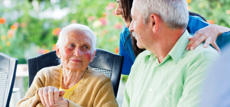 elder couple looking into each others eyes while a nurse smiles down at them