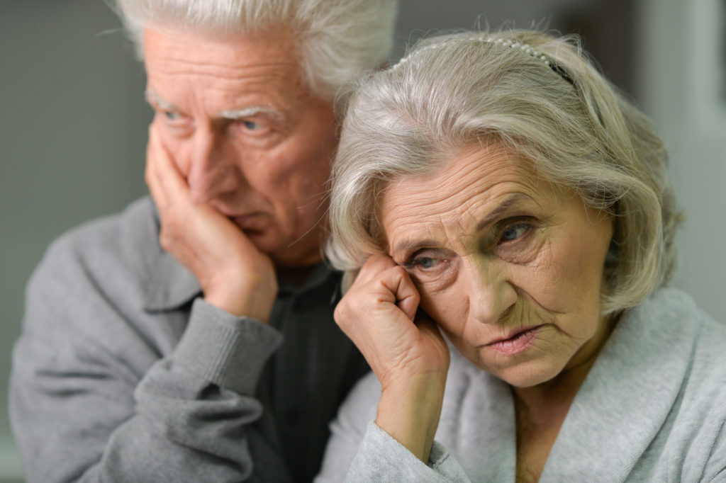 elder couple standing with worried looks on their faces