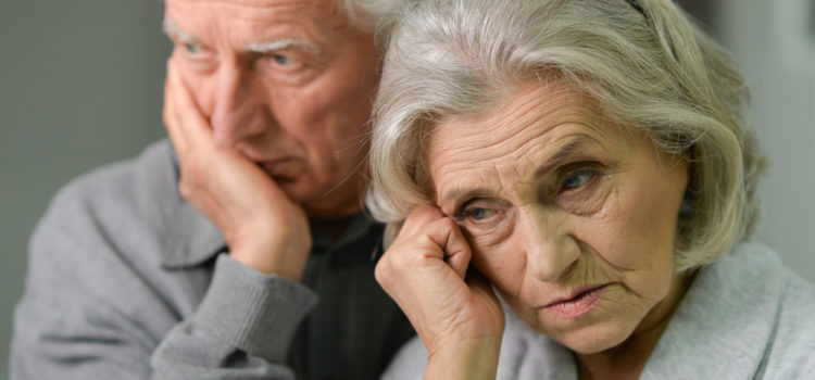 elder couple standing with worried looks on their faces