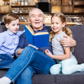 Grandfather reading a book to his grandchildren